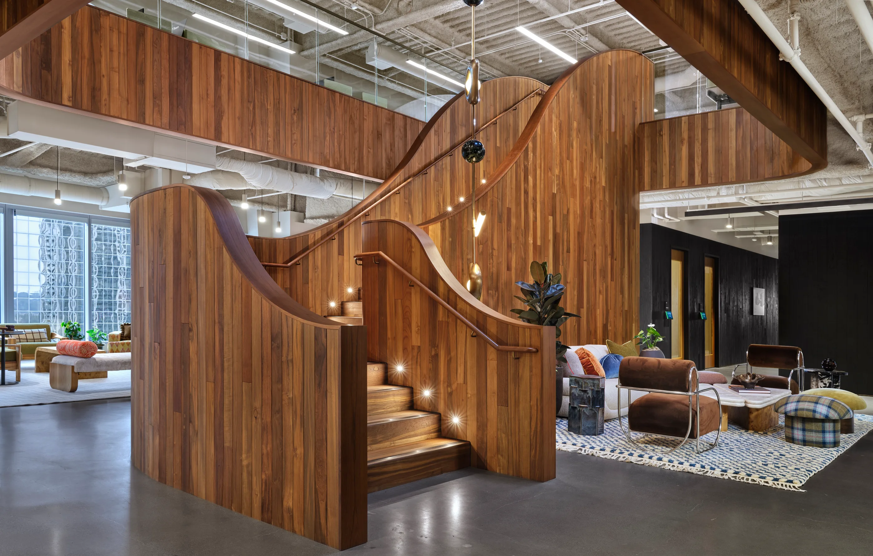 The finished wood stair at Bellevue with a lounge seating group at its base.